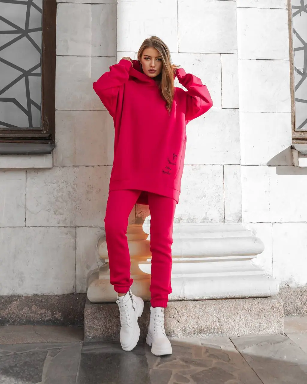 Girl standing near a house wearing a tracksuit